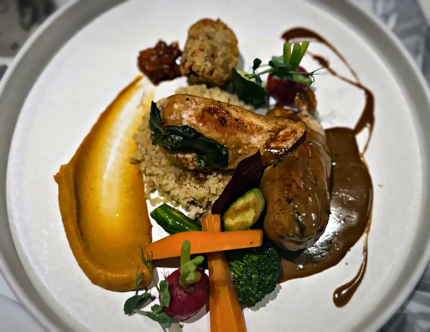 Stuffed chicken breast on quinoa with pumpkin purée and baby vegetables
